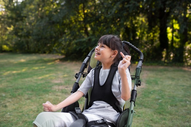 A young girl seated comfortably in a stroller, enjoying her surroundings with a cheerful expression.