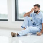 exhausted male nurse sitting on the floor