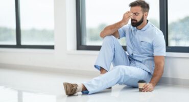 exhausted male nurse sitting on the floor