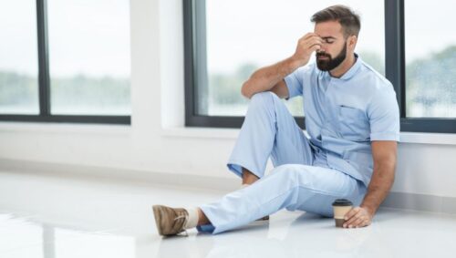 exhausted male nurse sitting on the floor